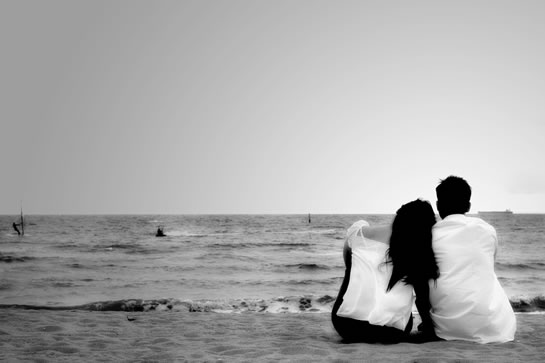Romantic Couple Sitting On A Beach.