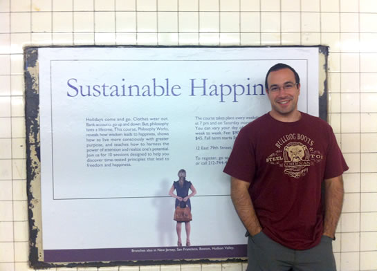 Ben Nadel in front of the Sustainable Happiness poster put up in the New York City subway system by the School of Practical Philosophy.