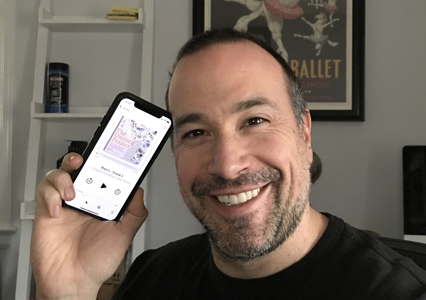 Ben Nadel holding his iPhone with The Unicorn Project audiobook on it.
