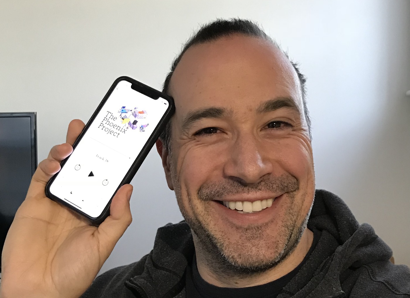 Ben Nadel holding an iPhone with iBooks showing The Phoenix Project.